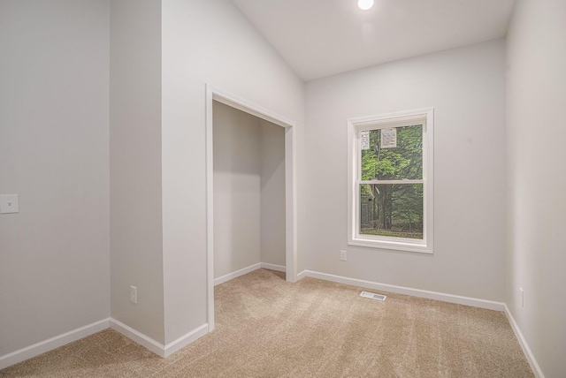 empty room with light carpet and baseboards