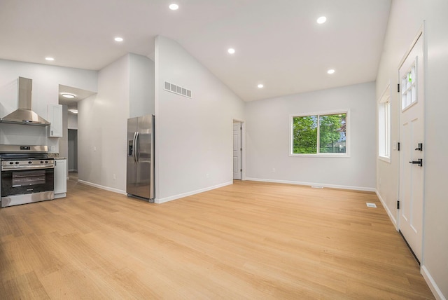 unfurnished living room with lofted ceiling, light wood finished floors, baseboards, and recessed lighting