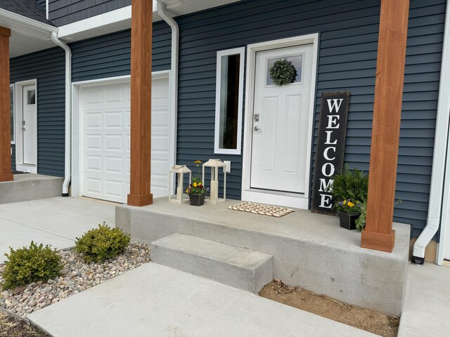 887 Rex St, Fremont, MI 49412 - view of exterior entry featuring a garage and a porch