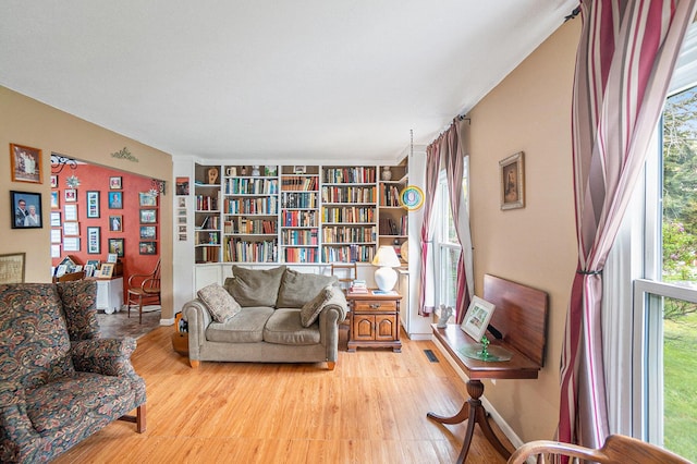 sitting room featuring healthy amount of natural light, wood finished floors, and built in features