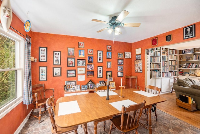 office area with ceiling fan, stone finish flooring, and baseboards