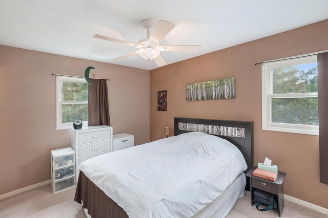 bedroom featuring light colored carpet, multiple windows, and baseboards