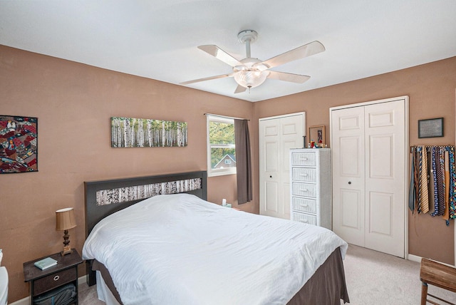 bedroom with multiple closets, light carpet, baseboards, and ceiling fan
