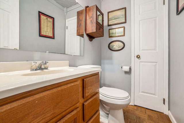 bathroom with vanity, toilet, and baseboards