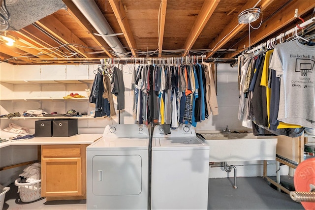 clothes washing area with washing machine and dryer and cabinet space