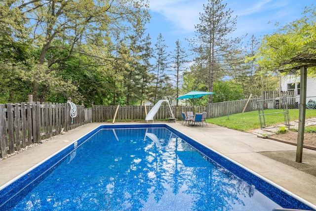 view of pool featuring a water slide, a fenced backyard, and a patio