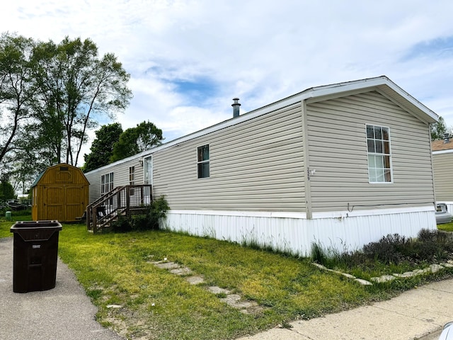 1950 S 13th St Lot 229, Niles, MI 49120 - view of side of property with a storage shed, an outdoor structure, and a yard