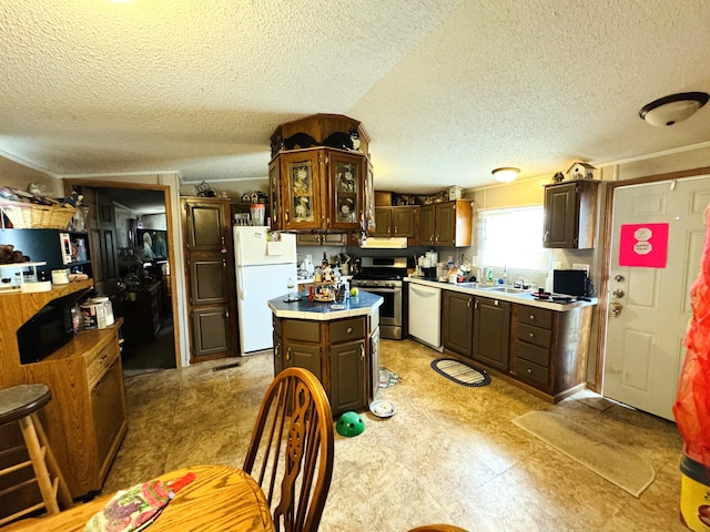 1950 S 13th St Lot 229, Niles, MI 49120 - kitchen featuring white appliances, a textured ceiling, dark brown cabinets, light countertops, and a kitchen island