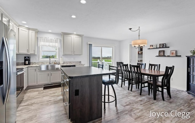 4755 Boulder Dr, Holland, MI 49423 - kitchen with a sink, a kitchen island, recessed lighting, a kitchen bar, and light wood-style floors