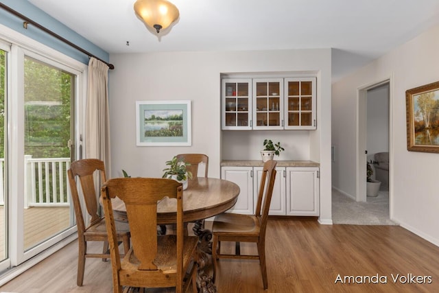 dining area with light wood-style floors and baseboards