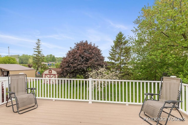 deck featuring a shed, a lawn, and an outdoor structure