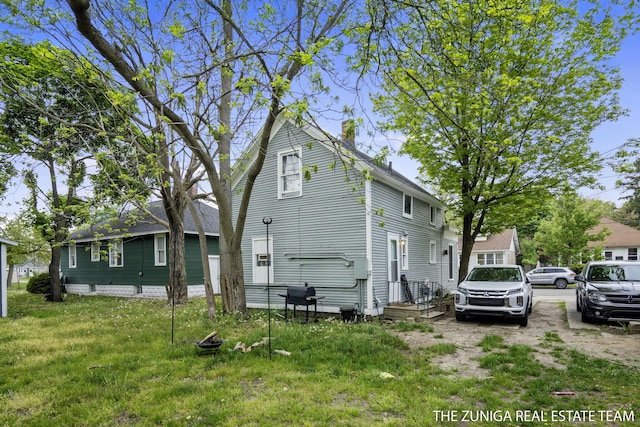 view of property exterior featuring a chimney and a yard