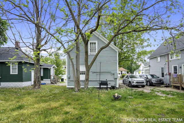 back of house featuring entry steps and a yard