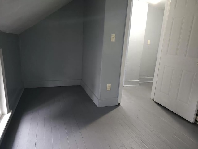 bonus room with hardwood / wood-style flooring and baseboards