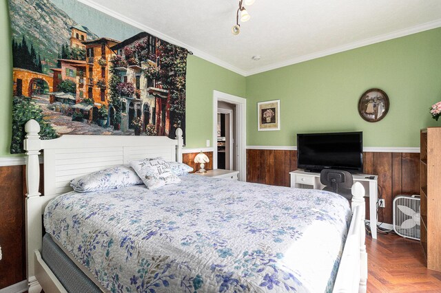 705.5 E Ludington Ave, Ludington, MI 49431 - bedroom featuring wainscoting, ornamental molding, and wooden walls