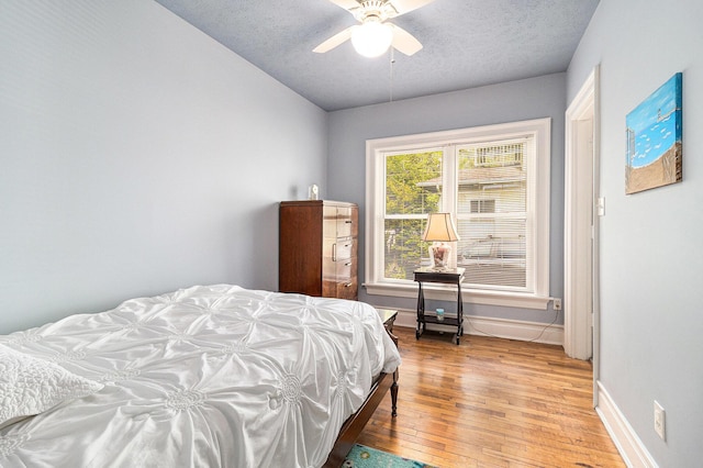 705.5 E Ludington Ave, Ludington, MI 49431 - bedroom featuring light wood finished floors, baseboards, a textured ceiling, and a ceiling fan