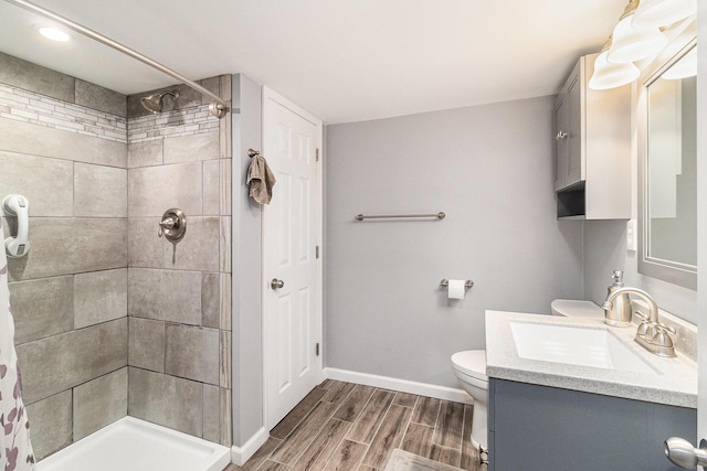 705.5 E Ludington Ave, Ludington, MI 49431 - full bath featuring toilet, a tile shower, vanity, wood finished floors, and baseboards