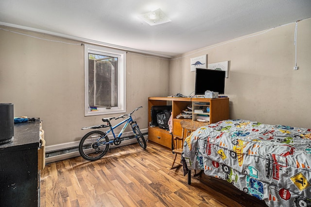 bedroom featuring wood finished floors and baseboard heating