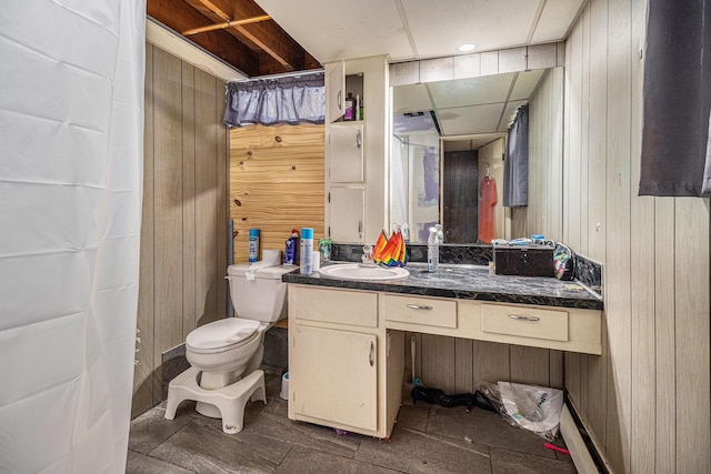 full bath with wooden walls, vanity, and toilet