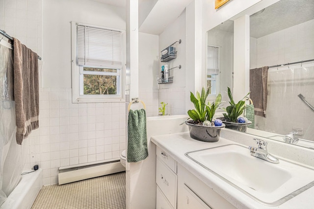 bathroom featuring a baseboard heating unit, vanity, tile walls, and tile patterned floors