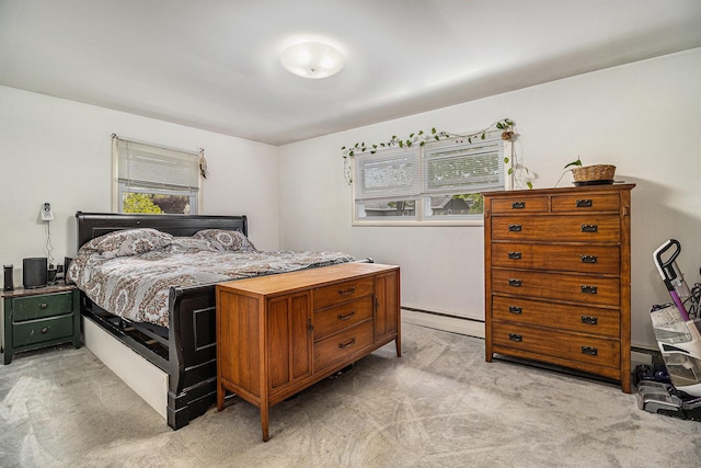 bedroom featuring light colored carpet, multiple windows, and a baseboard heating unit