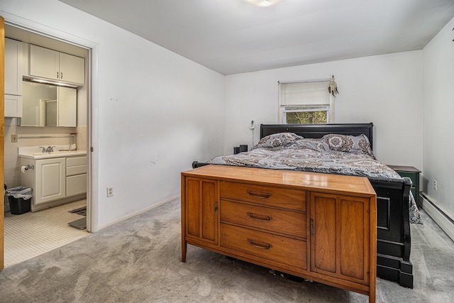 bedroom with light carpet, a sink, ensuite bath, baseboards, and a baseboard heating unit