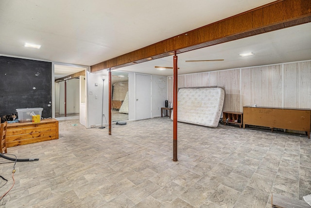 finished below grade area featuring wood walls and stone finish floors