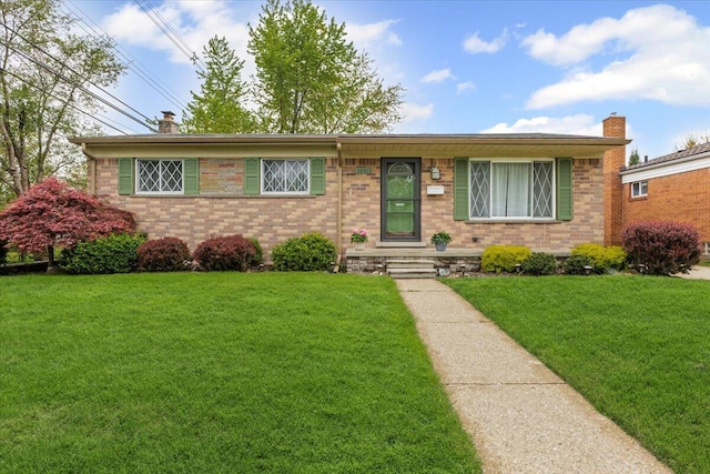 single story home with a chimney, a front lawn, and brick siding