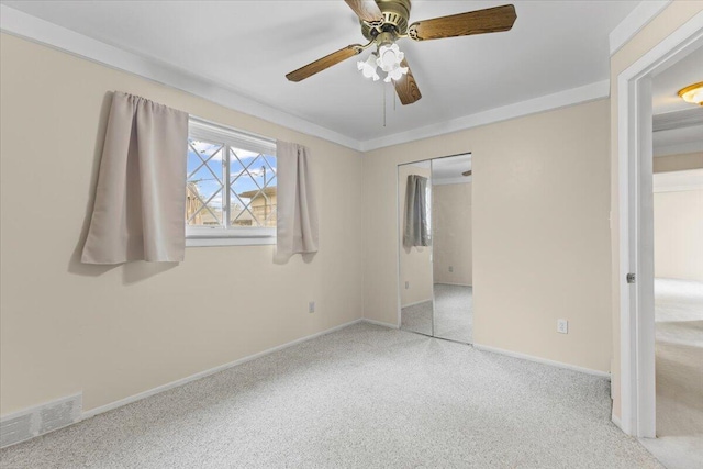 unfurnished bedroom featuring carpet flooring, baseboards, ceiling fan, and a closet