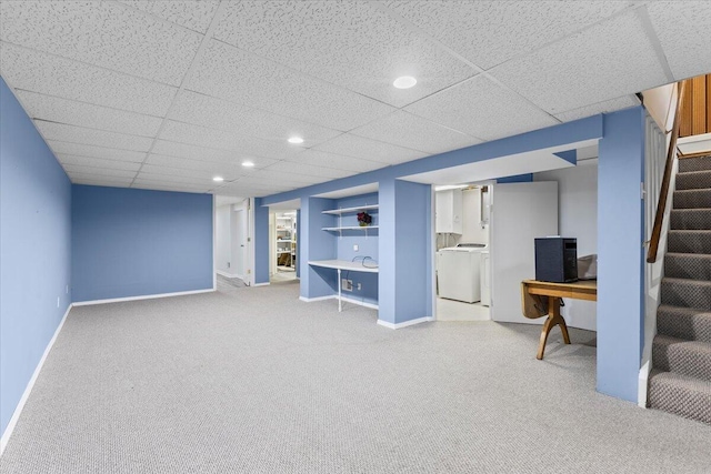 finished below grade area featuring washer / clothes dryer, stairs, carpet floors, built in shelves, and baseboards