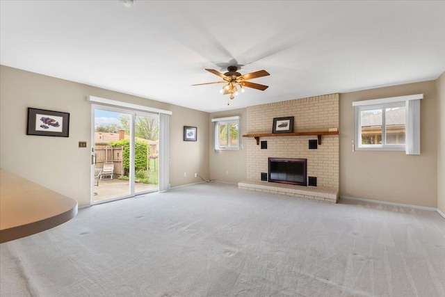 unfurnished living room with a ceiling fan, carpet flooring, baseboards, and a fireplace