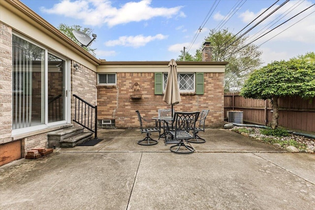 view of patio with fence, entry steps, central AC unit, and outdoor dining space