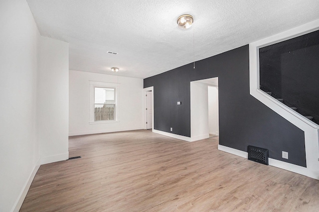2145 Horton Ave SE, Grand Rapids, MI 49507 - spare room featuring wood finished floors, a textured ceiling, and baseboards