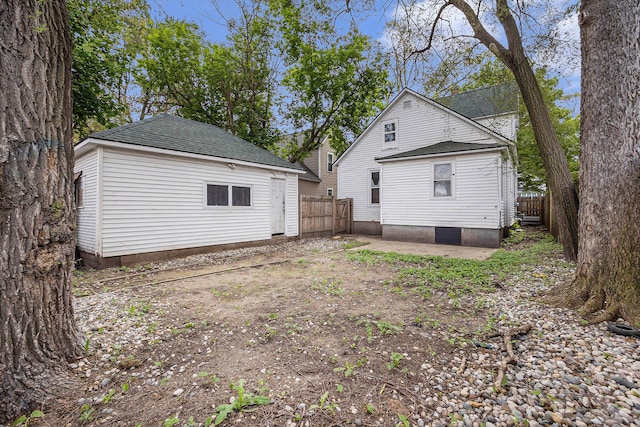 2145 Horton Ave SE, Grand Rapids, MI 49507 - back of house with fence, a shingled roof, and an outbuilding