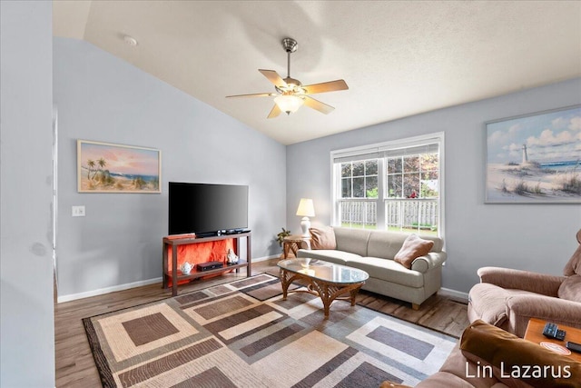 living room featuring vaulted ceiling, wood finished floors, ceiling fan, and baseboards