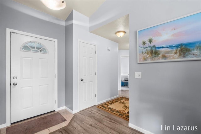 foyer with wood finished floors and baseboards