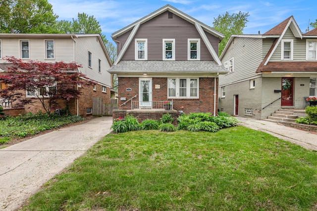 223 N Edison, Royal Oak, MI 48067 - colonial inspired home featuring a gambrel roof, brick siding, a front lawn, driveway, and roof with shingles
