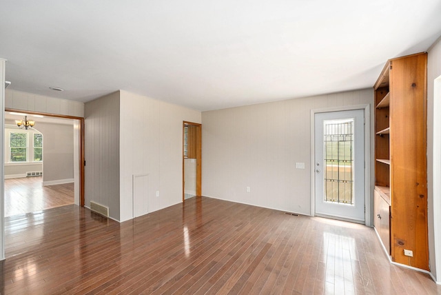 223 N Edison, Royal Oak, MI 48067 - unfurnished living room featuring a chandelier, light wood-style floors, and wooden walls