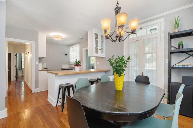 1950 Robinson Rd SE, East Grand Rapids, MI 49506 - dining area featuring a chandelier, light wood-style flooring, and baseboards