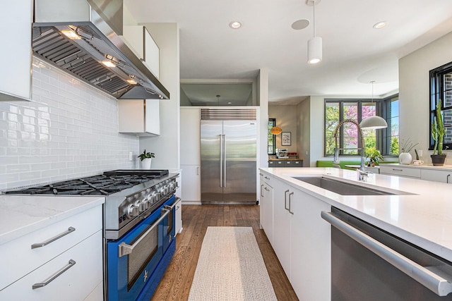 1950 Robinson Rd SE, East Grand Rapids, MI 49506 - kitchen featuring premium appliances, wall chimney range hood, a sink, white cabinets, and recessed lighting