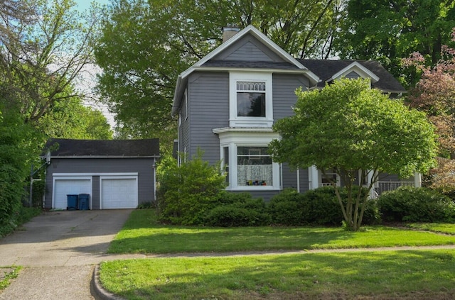 view of front facade with an outbuilding, a front lawn, a chimney, and a garage