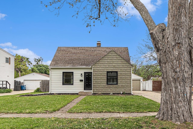 view of front of home featuring a garage, roof with shingles, a chimney, and an outbuilding