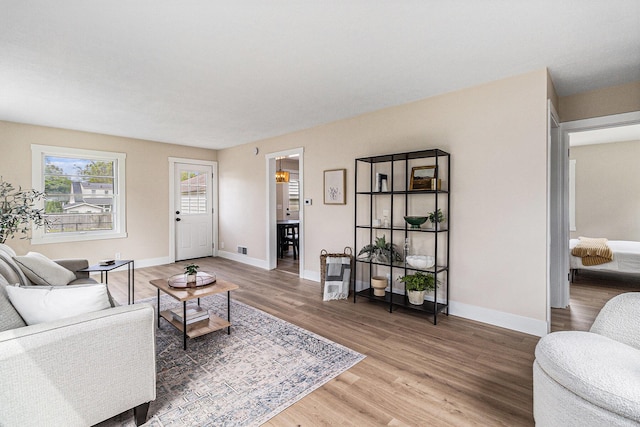living area with light wood-type flooring and baseboards