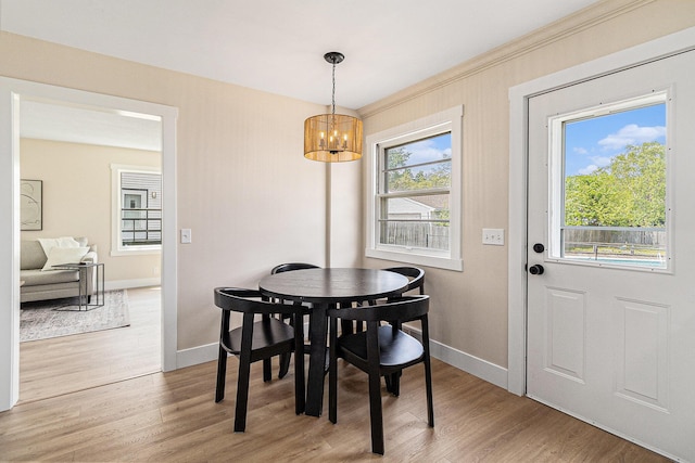 dining room with a chandelier, baseboards, and light wood-style floors