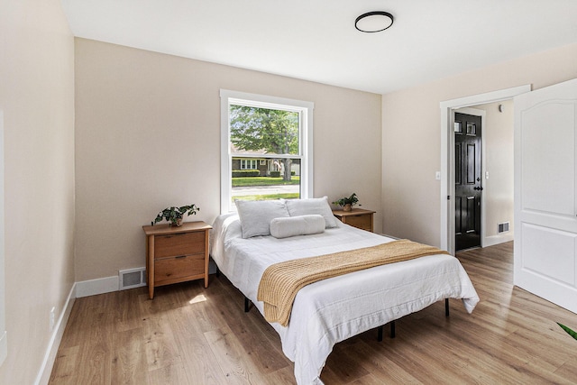 bedroom with light wood-style floors and baseboards
