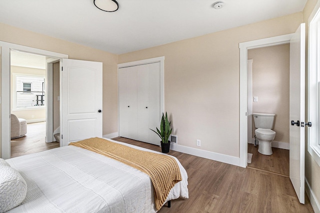bedroom featuring baseboards, a closet, and wood finished floors