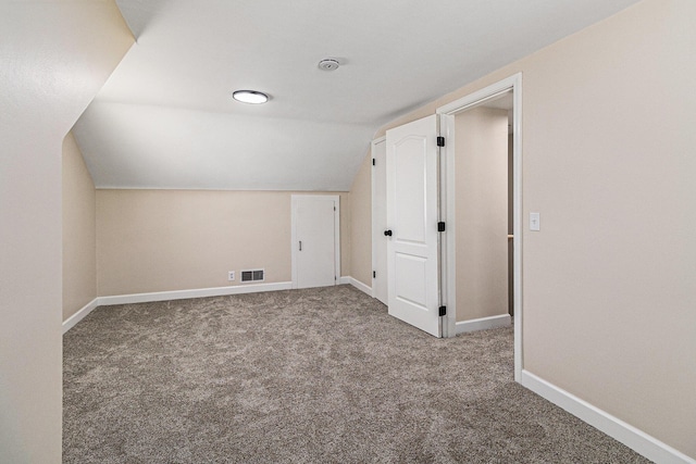 additional living space with carpet flooring, lofted ceiling, and baseboards