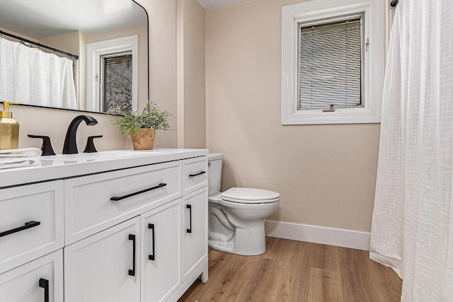 full bathroom with baseboards, toilet, wood finished floors, vanity, and curtained shower