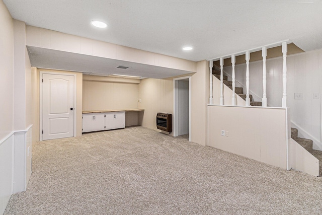 finished below grade area with heating unit, carpet, stairway, and recessed lighting