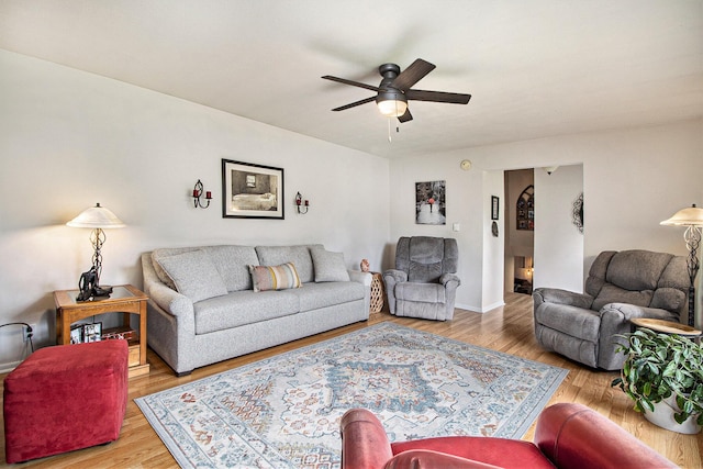 living area with a ceiling fan, wood finished floors, and baseboards